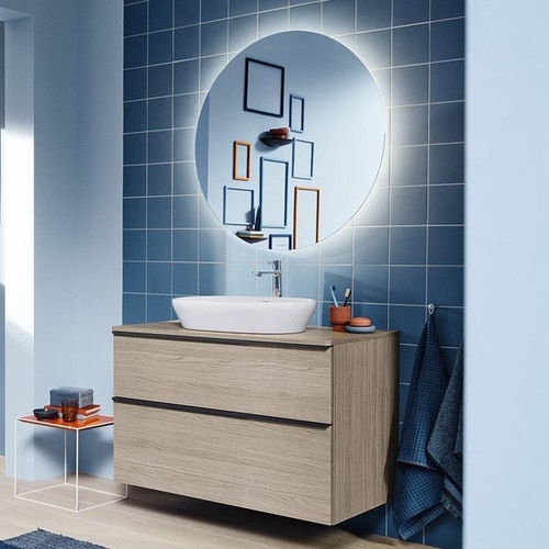 Immagine di Duravit D-NEO composizione bagno: mobile sottolavabo sospeso, finitura rovere terra + specchio Ø 70 con illuminazione, versione "Good" + lavabo da appoggio 60 cm, colore bianco + miscelatore monocomando L, finitura cromo LM785100000+DE496803535