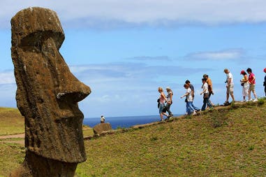 Moai e turisti sullo sfondo sull'isola di Pasqua in Cile