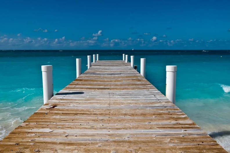 A wooden gangway goes into sea in Turks and Caicos Islands
