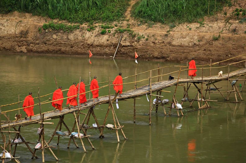 monks-walking-skip-on-the-river-with-bamboo-bridge-louangphrabang-laos