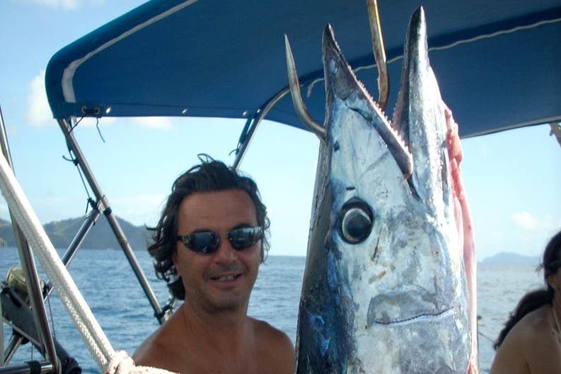 Skipper con pesce pescato a bordo della barca a vela Feeling 486
