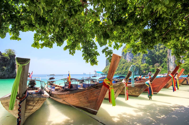 Typic thai boat on the white sandy beach of Thailand